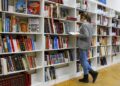 A woman immersed in a book, experiencing the transformative effects of reading on the brain in a serene library setting.