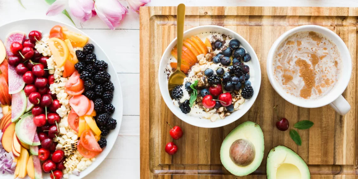 A bowl of fruit and a cup of coffee on a wooden cutting board, creating the perfect morning boost with a burst of natural energy.