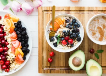 A bowl of fruit and a cup of coffee on a wooden cutting board, creating the perfect morning boost with a burst of natural energy.