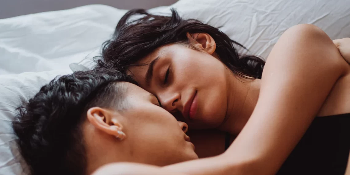 Why It's Good to Sleep Next to Your Partner - A man and woman embracing in bed, positively impacting mental health.