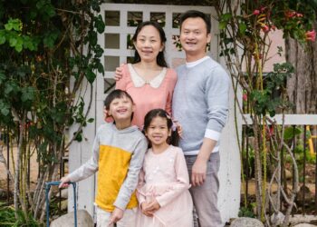 parents with a down syndrome son and cute daughter standing on a park