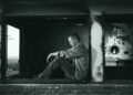 grayscale photo of man sitting