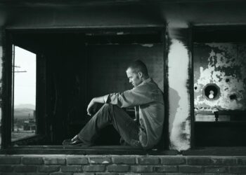 grayscale photo of man sitting